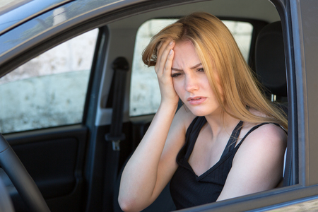 young female driver with headache in a carの写真素材