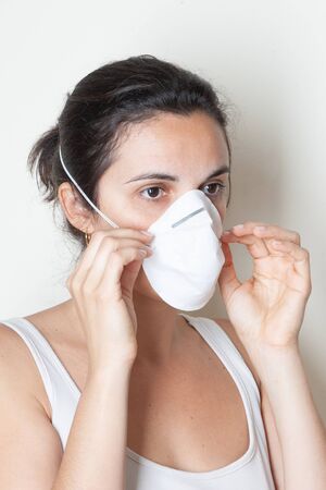 Woman putting on a protective mask because of the coronavirusの写真素材