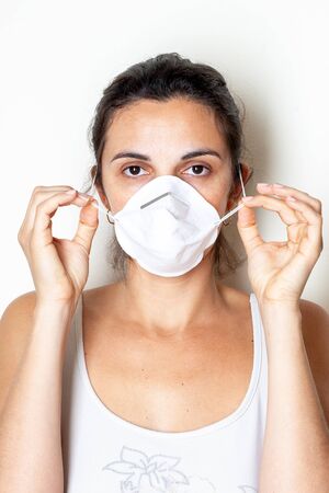 Woman putting on a protective mask because of the coronavirusの写真素材