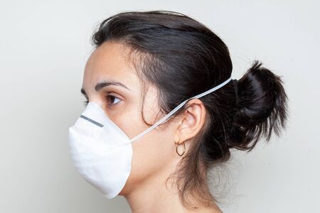 Woman putting on a protective mask because of the coronavirusの写真素材