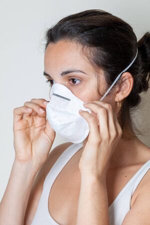 Woman putting on a protective mask because of the coronavirusの写真素材