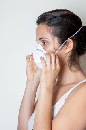 Woman putting on a protective mask because of the coronavirusの写真素材