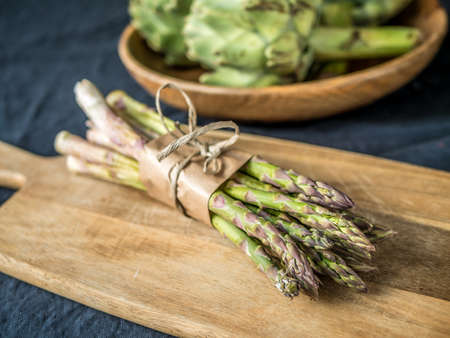 Fresh green asparagus on a wood cutting board.の写真素材