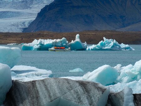 The tourist ship with tourists flows around JÃ¶kulsÃ¡rlÃ³n Lake. South Iceland
