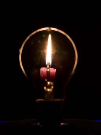 Lightbulb and candle flameの写真素材