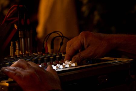 Hands and electronic sound mixer on stage