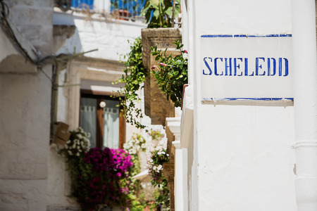 Road sign with street dialect name in a Puglia roadのeditorial素材