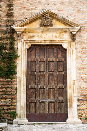 Ancient wooden door of the side entrance of the Cathedral San Massimo di Penne (Italy)の写真素材
