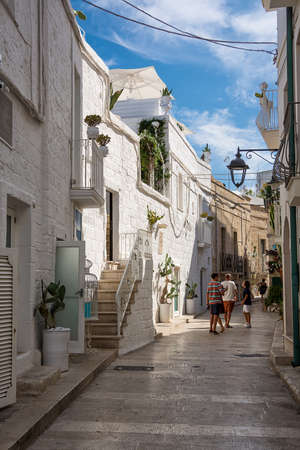 Monopoli, Italy - 20 August 2021: Pedestrian street in the old town of Monopoli with tourists (Puglia)のeditorial素材