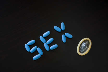 Written Sex composed with blue pills and condom, concept of use for male problems related to sex and...