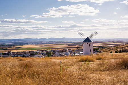 Dry field with ancient windmill and below the village of Campo de Criptana, Spain, defined in...