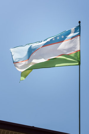 Uzbek flag waving in the wind in the skyの写真素材