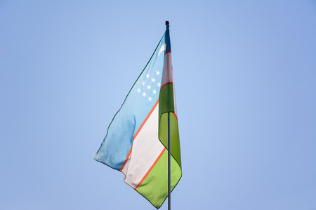 Uzbek flag waving in the wind in the skyの写真素材