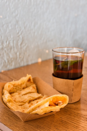 Glass of mint tea with chapati bread and cheese on a table