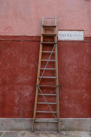 old ladder leaning against the wall of muranoの写真素材