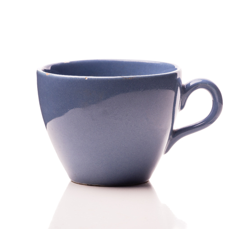 Old notched blue cup on a solid white backgroundの写真素材