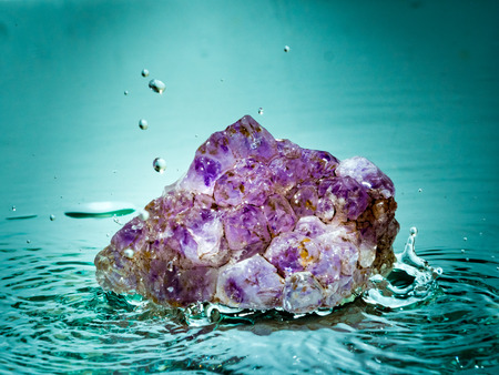 Solid mineral water in water surrounded by water splashesの写真素材