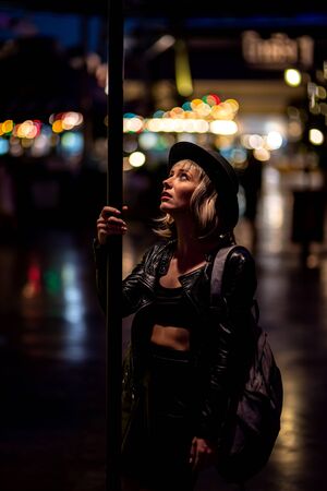 World of Adventures. Beautiful female tourist exploring night city alone. Copy space in upper part