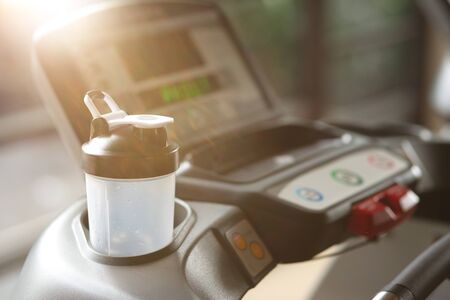 For your comfort. Digital screen of a treadmill and protein shaker standing on it. Copy spaceの写真素材