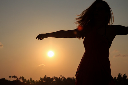 Silhouette of a girl enjoying the summer in Unawatuna beach, Sri Lankaの写真素材