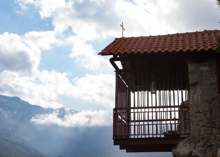 A cage balcony hanging in the sky. Shot in a monastery in mountainous Corinthia region, in Greece.の写真素材