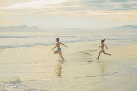2 Papuan children who are enjoying the beautiful beach in the morningの写真素材