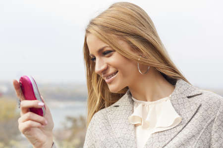 Young Woman with mobile phone walking background is blured cityの写真素材