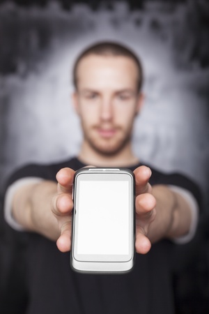 Man showing screen of smartphone, black t-shirt and background, studio shotの写真素材