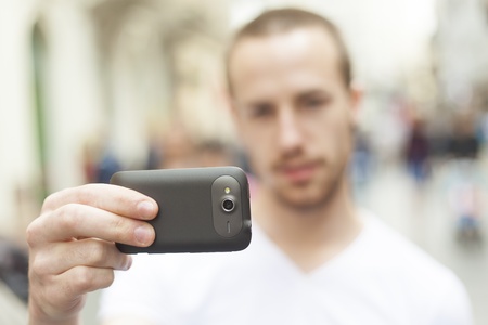 Urban photographer with mobila phone make photo on streetの写真素材