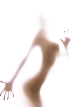 Blurred glass of bathroom hiding sexy female silhouetteの写真素材
