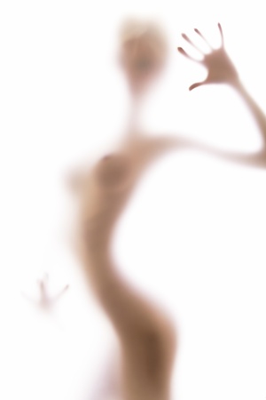 Sexy silhouette behind the blurred glass of bathroomの写真素材