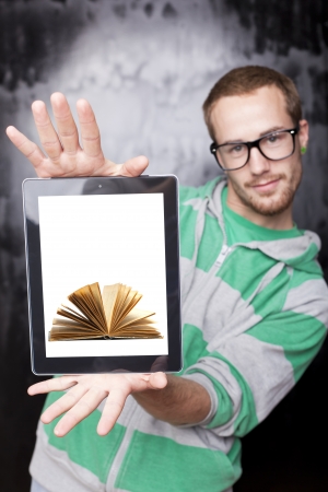 Digital library - Good Looking Young Nerd Smart Man Using Tablet Computer with book on screenの写真素材