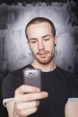 Man use smartphone, background is blured grayの写真素材