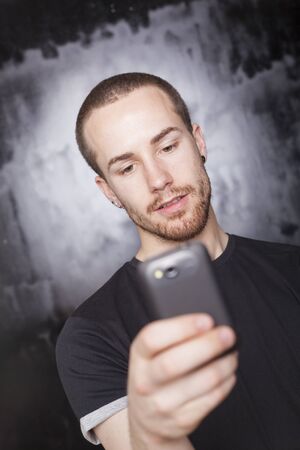 Man read SMS on mobile phone, background is bluredの写真素材