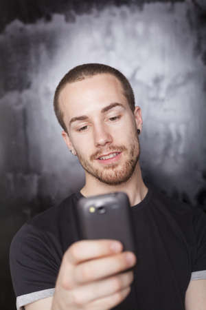 Man typing SMS with mobile phone, background is blured