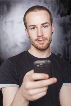 Man with mobile phone, background is bluredの写真素材