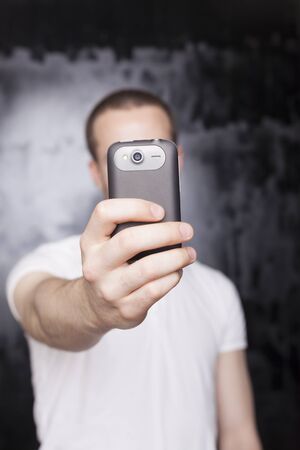 Man with mobile phone, background is bluredの写真素材