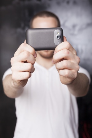Multimedia content on smartphone Man with mobile phone, background is bluredの写真素材