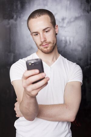 Guy receive sms, smartphone, background is bluredの写真素材