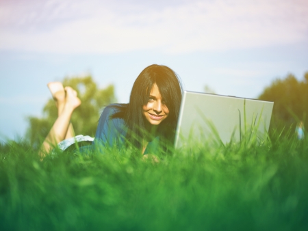 Young woman using laptop in parkの写真素材