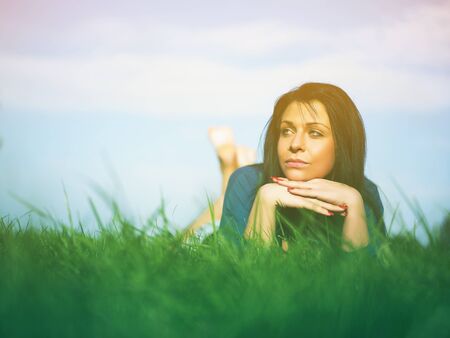 Young woman relaxing in park on green grassの写真素材