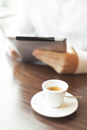 Man with tablet computer reading news at motning in cafe shopの写真素材