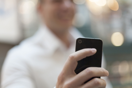 Man with smart phone on hand, blurred backgroundの写真素材