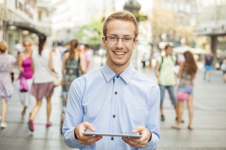 Young businessman using tablet computer in public space, group of peopleの写真素材