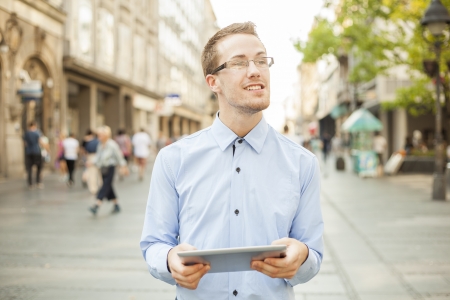 Businessman Man Using Tablet Computer in public space, street, cityの写真素材