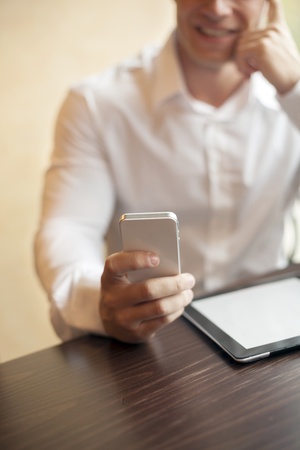 Man with smart phone in hand, blurred background, business building interiorの写真素材