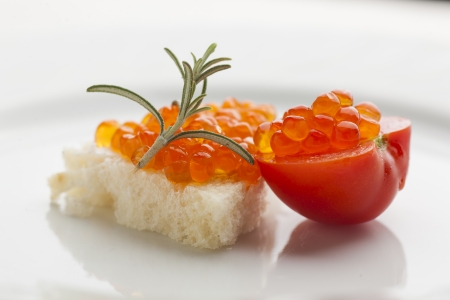 Perfect breakfast - Caviar sandwich with red cherry tomato on plate, decorated with rosemeryの写真素材