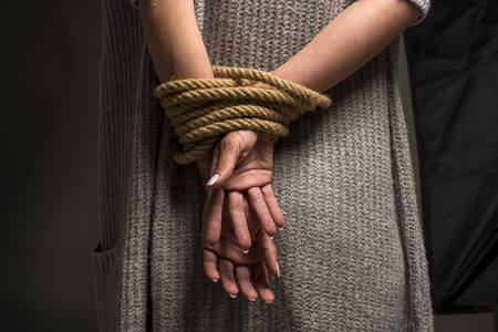 Womans hands on back tied with a rope, long nailsの写真素材