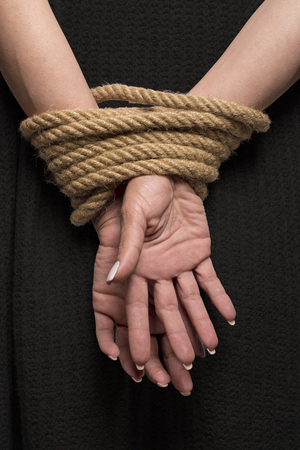 Womans hands on back tied with a rope, long nailsの写真素材