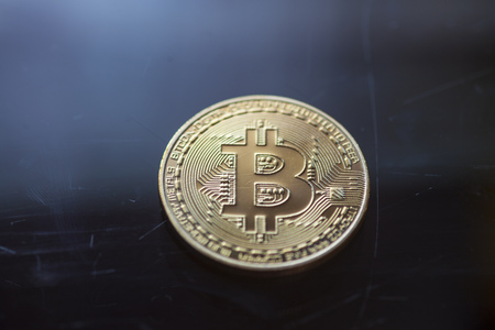 Bitcoin curency DOF on blue glass background. Gold metal curency symbol photoの写真素材